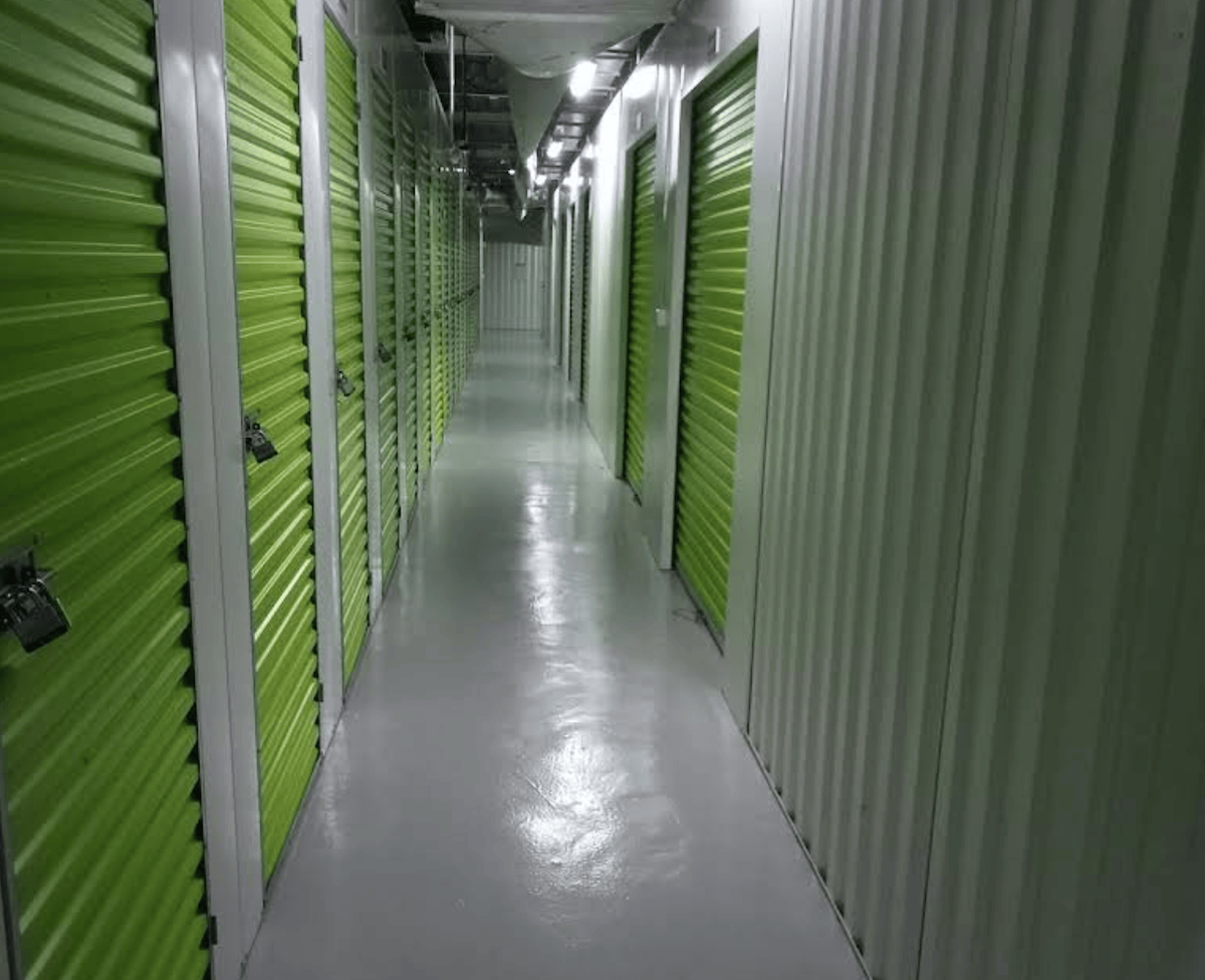 The Box JLT — interior corridor with bright green storage unit doors
